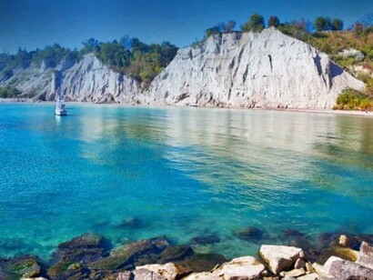 The lone sailing boat trying to reach the shores of Scarborough Bluffs, Canada after its voyage in Lake Ontario