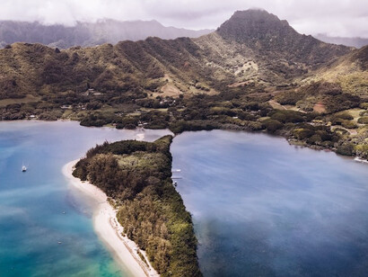 The scenic beauty of Oahu, Hawaii, from a bird's-eye perspective, showcasing the striking contrast between the majestic mountains and the vast ocean, providing a captivating glimpse of the island's natural splendor