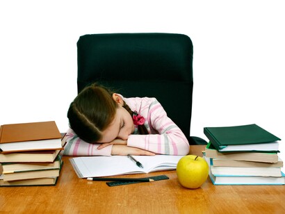 Una niña dormida sobre su escritorio