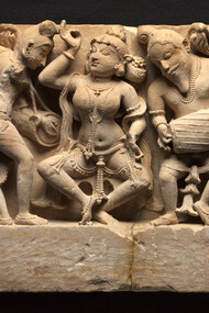 Frieze with Dancer and Musicians, a dancer, who strikes a pose in the center, is accompanied by a full orchestra of musicians in lively variegated poses. At the far left, a woman plays the cymbals, her mouth open in song, Northwestern India, Rajasthan, Sikar, Harshagiri, 10th century