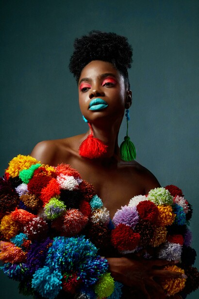 Uma mulher modelo vestindo uma roupa estilosa e cheia de cores. Cada look é uma narrativa visual que conecta estética, cultura e posicionamento