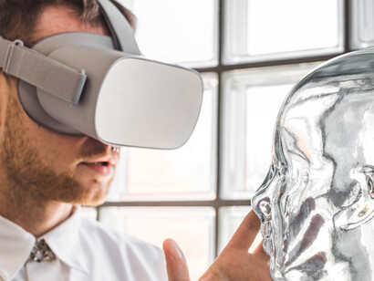 A young doctor wearing VR goggles examines a mannequin in a virtual simulation, representing future technology and AI–human interaction