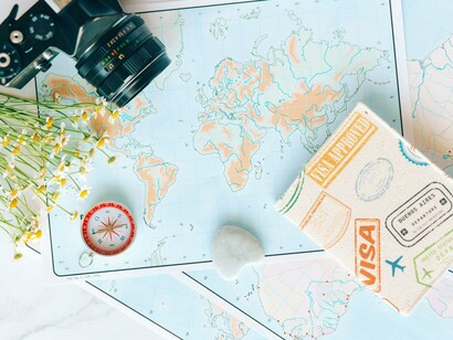 Bússola ao lado de um mapa e uma câmera