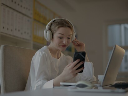 Mulher revisa o celular enquanto trabalha