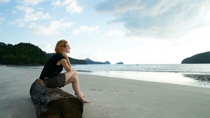 A woman alone on the beach as she manages silence 