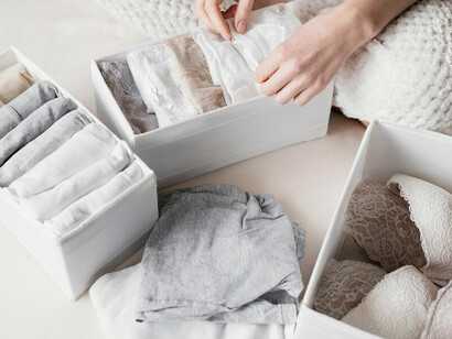 A woman arranging her closet with a minimalist style and a well-organized capsule wardrobe