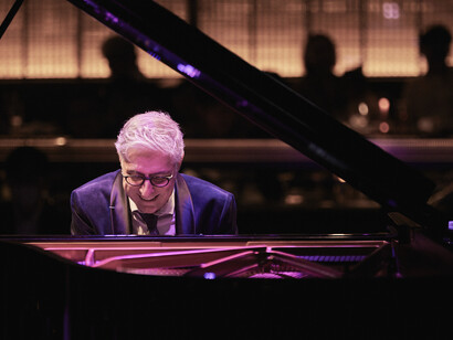 Giovanni Mirabassi smiling while playing the piano at Blue Note Tokyo, Japan © Yuka Yamaji