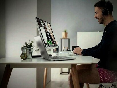 A man working remotely in his makeshift office while being half-dressed