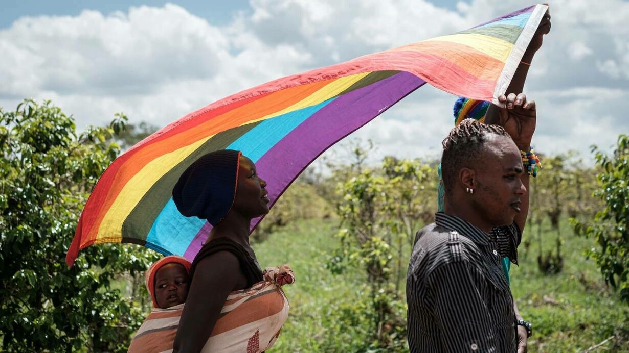 Members of the LGBTQ+ community marching with their flag in the Kakuma refugee camp in Kenya