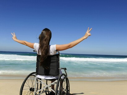 Una chica con silla de ruedas disfrutando de la playa