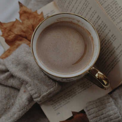 Hot chocolate in a white mug resting on a knitted blanket, evoking warmth, comfort, and the soothing, serotonin-boosting joy of chocolate