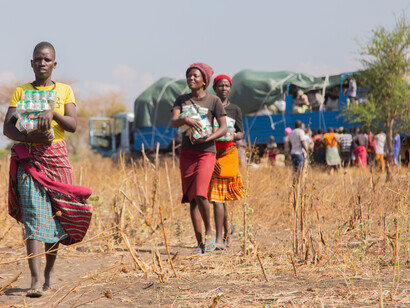 People receive humanitarian aid in a rural area of Sudan during the day