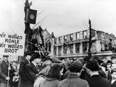 Des Marines américains engagés dans des combats de rue lors de la libération de Séoul. On remarque les fusils M-1 et les fusils automatiques Browning portés par les Marines, des Coréens morts dans la rue et des chars M-4 « Sherman » au loin