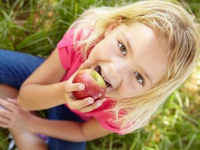 Una niña comiendo una manzana