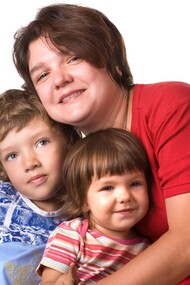 Una madre abraza a sus dos hijos
