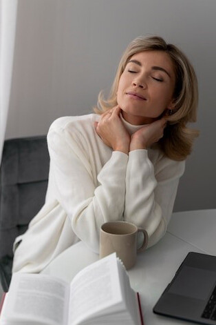 Quietly seated at her tranquil desk, a woman journals with intention, embracing mindfulness and personal reflectio