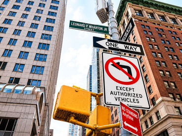Traffic signs on a Manhattan street corner, highlighting urban semiotics and directional symbolism in New York City, USA