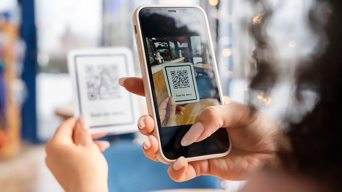Hands holding phone close up, scanning menu on phone