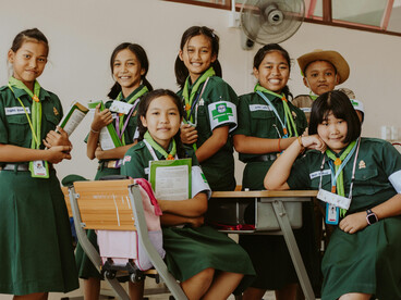 Diverse students in green school uniforms standing together