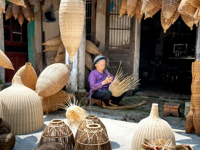 Artisans producing handmade woven baskets in a Vietnamese village, symbolizing how meaningful travel experiences can empower local businesses