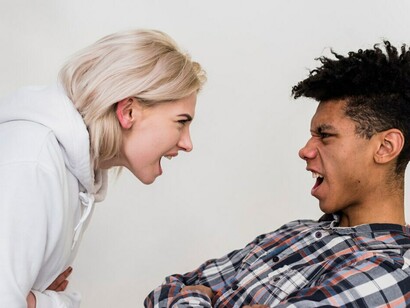 An interracial couple arguing against a white background, highlighting cultural misunderstandings, bias, and stereotypes