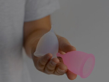 Woman folding menstrual cups, addressing period poverty and highlighting issues related to menstrual product access