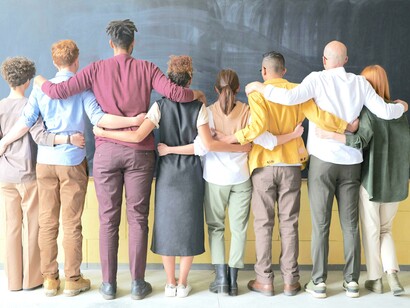Grupo de pessoas paradas ao lado de um quadro negro