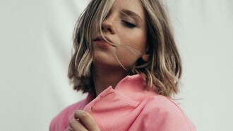 A woman wearing a desert rose color coat