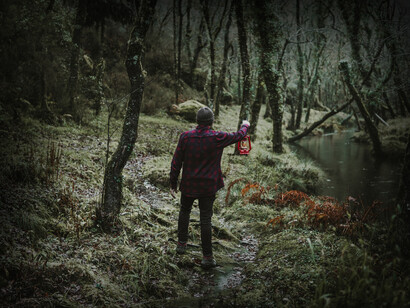 Hombre caminando bosque adentro en una tarde lluviosa por Betanzos en Galicia, España