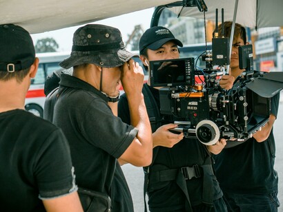 Movie crew standing together on set with cameras and lighting equipment ready for action