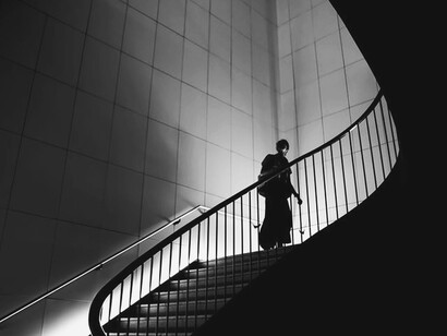 Pessoa sobe as escadas em forma de espiral como alusão aos devaneios da mente