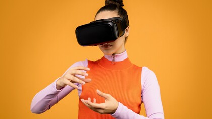 Menina usa óculos de realidade virtual e move as mãos