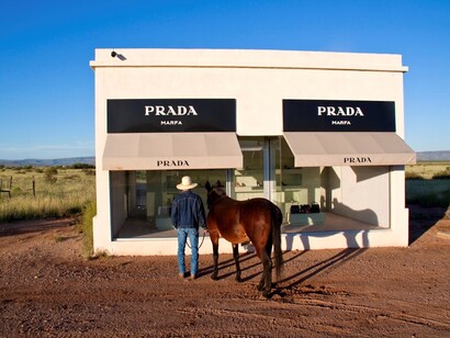 Un cowboy tejano mirando el escaparate de Prada Marfa