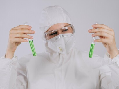 Pesquisadora examina uma amostra contida em um tubo de ensaio durante um procedimento de laboratório. A precisão dessas análises está relacionada à discussão do artigo sobre a detecção de contaminantes em níveis vestigiais