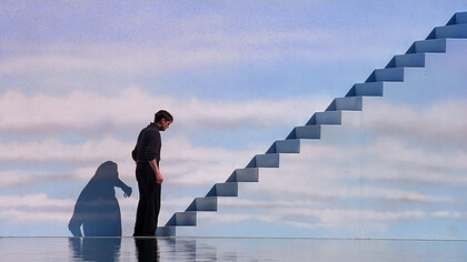Truman (Jim Carrey) en un momento de contemplación antes de subir la escalera. “The Truman Show” (1998)