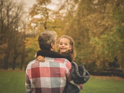 Un padre pasea con su hija en una tarde de otoño