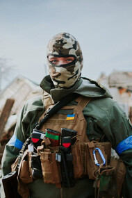 A solemn Ukrainian soldier gazes at the camera, embodying the steadfast resolve in defending homeland amidst turmoil