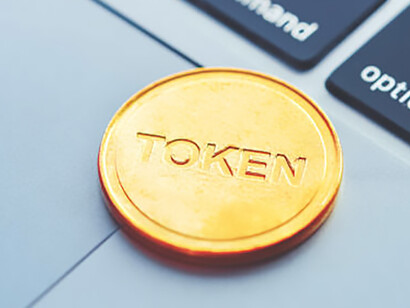 Golden coin with 'Token' inscription placed on a modern laptop, symbolizing digital assets and blockchain technology integration