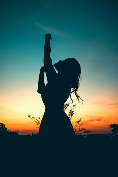 A lone silhouette beneath a crescent moon gazes into a star-filled sky, illuminated by a softly glowing path