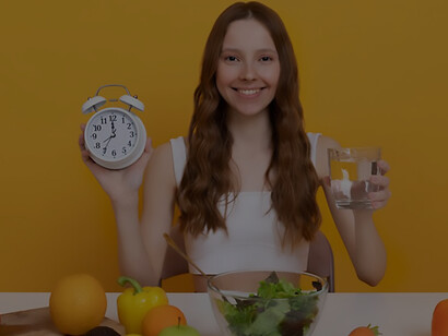 Elevate your content with a medium shot featuring a woman showcasing fresh fruits and vegetables alongside water, symbolizing the essence of a healthy lifestyle and its impact on aging gracefully