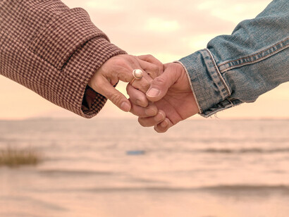 Un hombre y una mujer se toman de la mano frente al mar en Hong Kong, China