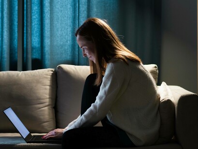 Donna sul divano davanti al computer: "È una modalità comunicativa che stiamo sperimentando da pochissimi anni, il tempo di un battito di ciglia rispetto a quello della nostra esistenza su questo pianeta"