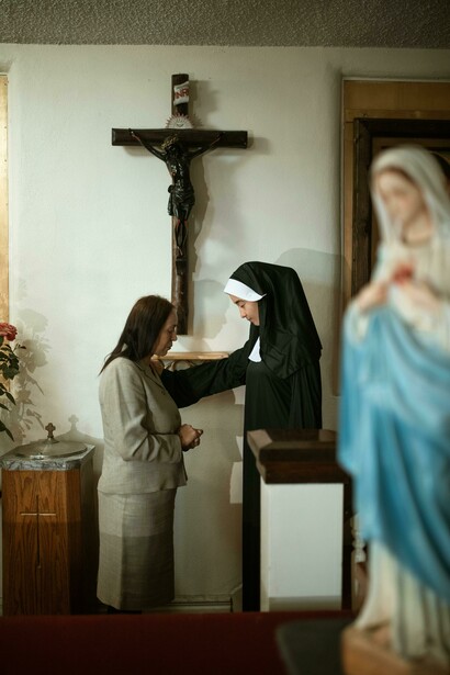Monja bendiciendo a una mujer