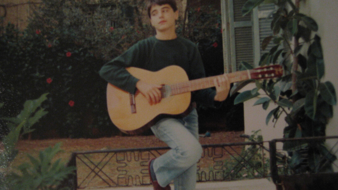 Young Yasser Mroué playing the guitar. From Rabih Mroué, Riding on a Cloud, 2013.