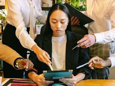 A young professional surrounded by colleagues offering guidance and feedback, representing workplace expectations and accountability