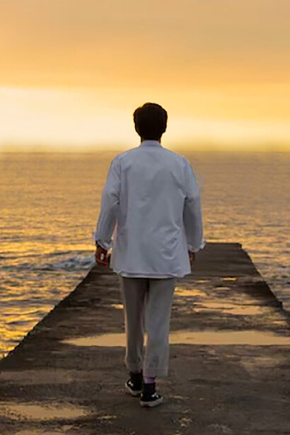 A solitary man at the shoreline, reflecting on life, ready to let go and move forward