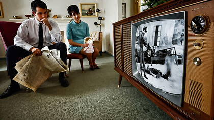 A family watches televised war coverage on the evening new