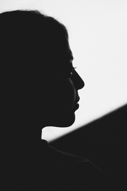 A solitary girl’s silhouette stands as a metaphor for the fragility and fluidity of identity
