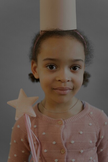 Menina negra sorridente em traje de princesa com coroa