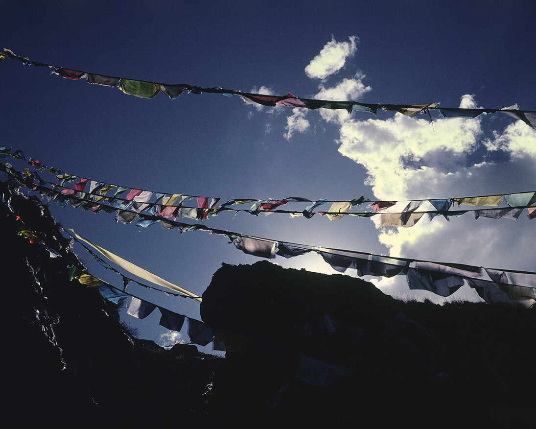 Marissa Roth, Prayer flags on a high pass overlooking Jalsa, a towering eleventh-century Buddha cut into the rock face, near Lhasa. September 2010. © Marissa Roth.
